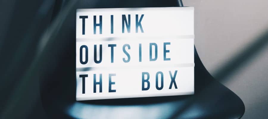 Lightbox sign sitting on a chair with the text "think outside the box"