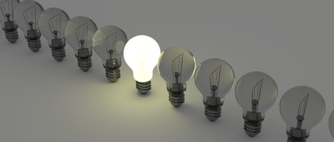 A single lit light bulb in a row of unlit ones